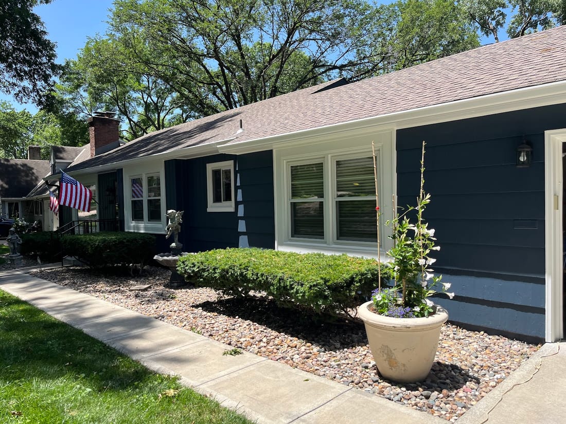 Deep charcoal exterior repaint with crisp white trim on a Kansas City home