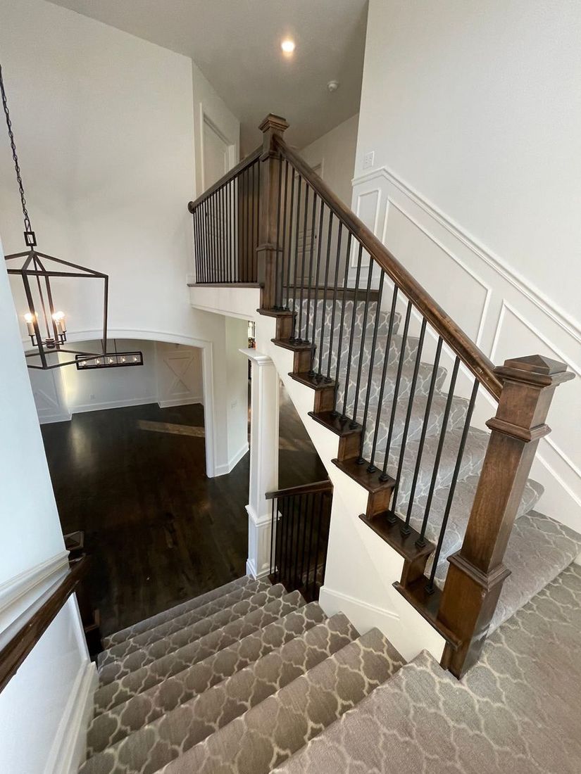 Freshly finished stairwell with dark stained rail and crisp white trim